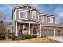 Charming two-story home with stone accents, a covered front porch, and a well-maintained lawn at 23549 E Ottawa Pl, Aurora, CO 80016