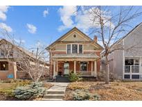 Charming two-story brick home with a covered front porch and well-manicured landscaping at 1562 Madison St, Denver, CO 80206