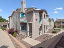 Beautiful multi-Gathering home with gray siding, blue accents, and well-maintained landscaping at 3855 Canyon Ranch Rd # 104, Highlands Ranch, CO 80126