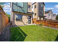 Well-maintained front yard featuring green grass and a privacy fence surrounding the home at 1415 Irving St, Denver, CO 80204