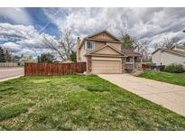 Charming two-story home featuring a brick-accented garage and inviting front porch, complemented by a well-maintained lawn at 6057 S Pierson St, Littleton, CO 80127
