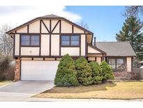 Charming two-story home with Tudor-style architecture, attached garage, and well-maintained landscaping at 6156 W Jefferson Ave, Denver, CO 80235