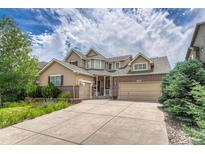 Attractive two-story home featuring a three-car garage, well-maintained lawn, and beautiful landscaping at 15886 E Stargazer Ln, Parker, CO 80134