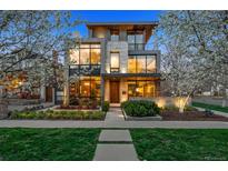 Contemporary home with large windows, stone accents, and landscaped front yard at dusk at 2539 E 5Th Ave, Denver, CO 80206