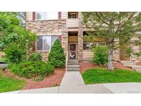 Charming condo features a stone facade with well-manicured landscaping and a welcoming front entrance at 7111 S Wenatchee Way # C, Aurora, CO 80016