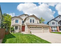 Charming two-story home features a three-car garage, red door, and well-manicured lawn at 775 Poppywood Dr, Highlands Ranch, CO 80126