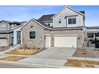 Charming two-story home featuring a stone facade, two-car garage and inviting curb appeal at 6400 Barnstead Dr, Castle Pines, CO 80108