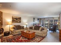 Inviting living room with comfortable seating, a rustic stone fireplace, and a vibrant Persian rug at 305 S Park Ave # 205, Breckenridge, CO 80424