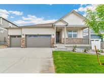 Charming single-Gathering home featuring a welcoming front porch, gray siding, and an attached two-car garage at 4708 Windmill Dr, Brighton, CO 80601