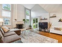 Bright living room features a fireplace, vaulted ceilings, and sliding glass door leading to outdoor area at 14121 E Baltic Pl, Aurora, CO 80014