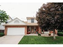 Charming two-story brick home with a well-manicured lawn and inviting front porch at 17530 E Caspian Pl, Aurora, CO 80013