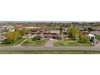 Expansive front yard featuring a circular driveway, lush lawn, and mature trees at 12941 W 75Th Ave, Arvada, CO 80005