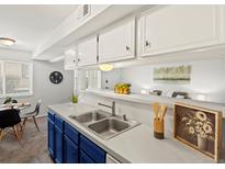 Kitchen area featuring stainless steel sink, blue cabinets, and eat-in dining at 7700 W Glasgow Place # 15A, Littleton, CO 80128