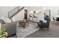 Cozy living space with bar stool seating, soft rug, and view into kitchen area at 7700 W Glasgow Place # 15A, Littleton, CO 80128