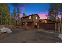 Inviting two-story home with a charming front porch and a detached garage in a wooded setting at 10858 Norton Ave, Conifer, CO 80433
