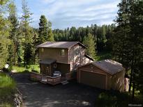 Charming exterior view of a two-story home with a deck and a detached garage at 10858 Norton Ave, Conifer, CO 80433