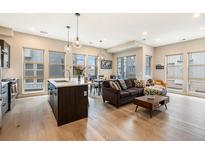Bright open-concept living room featuring hardwood floors and large windows at 2695 W Grand Ave, Littleton, CO 80123