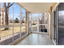 Bright sunroom with tiled floor and sliding door access to the outside with lovely view at 3082 S Wheeling Way # 106, Aurora, CO 80014