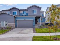 Charming two-story home with a blue-gray color scheme and a well-manicured front yard at 6882 Oak Canyon Cir, Castle Pines, CO 80108