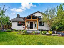 Charming two-story home with landscaped front yard and inviting covered porch with wooden beams at 1801 Redwood Ave, Boulder, CO 80304