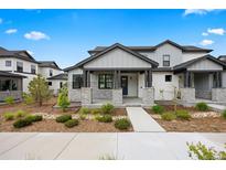 Charming two-story home featuring a covered porch with stone accents and well-maintained landscaping at 7040 Homeplace St, Castle Rock, CO 80108