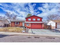 Charming red brick two-story home featuring an attached two-car garage and a well-maintained front yard at 3035 S Biscay St, Aurora, CO 80013