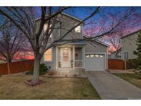 Charming two-story home with a well-maintained lawn and a single-car garage during the evening at 1495 Hummingbird Cir, Brighton, CO 80601