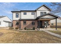 Charming two-story home featuring a brick facade, white siding, and a welcoming covered front porch at 2480 Quitman St, Denver, CO 80212