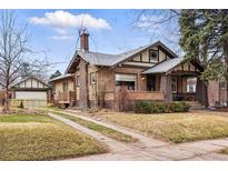 Charming brick home featuring a well-manicured lawn and inviting front porch at 925 Steele St, Denver, CO 80206