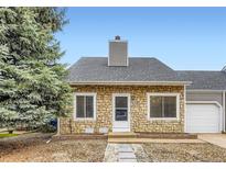 Charming stone-front home with a well-manicured yard and a classic, inviting entryway at 19481 E Milan Cir, Aurora, CO 80013