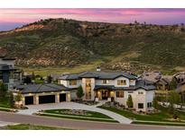 Stunning exterior elevation of a modern home, featuring a three-car garage and mountain views at 15191 Dinosaur Ridge Rd, Morrison, CO 80465