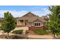 Charming single-Gathering home with a brick foundation, covered porch, and well-manicured landscaping at 22873 E David Pl, Aurora, CO 80016