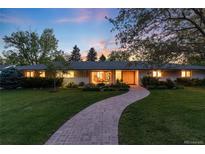 Charming single-story home with manicured lawn, lush landscaping, and brick walkway leading to the front door at 3925 S Cherry St, Englewood, CO 80113