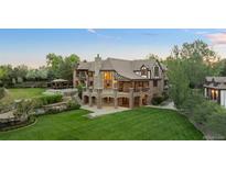 Expansive home features a lush lawn, stone accents, and a charming gazebo at 6616 E Prentice Ave, Greenwood Village, CO 80111