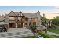 A stunning brick home with a stone chimney and a large outdoor patio area at 6616 E Prentice Ave, Greenwood Village, CO 80111