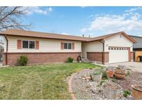 Charming single-story home with brick accents, a well-maintained lawn, and mature landscaping at 9698 Pecos St, Thornton, CO 80260