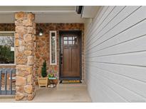Charming home entrance featuring a beautiful wood door, stone accents, and a welcoming decor at 9249 Fox Fire Dr, Highlands Ranch, CO 80129