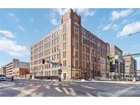 Brick warehouse loft building with large windows, located in a vibrant urban neighborhood with street signage at 1863 Wazee St # 6E, Denver, CO 80202