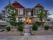 Inviting townhouse featuring colorful exterior, stone accents, landscaped front yard, and a charming entryway at 23545 E Platte Dr # C, Aurora, CO 80016