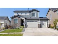 Charming two-story home featuring a three car garage, stone accents and neutral gray paint at 3989 Gold Bug St, Aurora, CO 80019