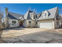 Charming home featuring a multi-car garage, distinctive roofline, and a well-maintained front yard at 7672 E Arizona Dr, Denver, CO 80231