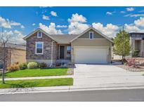 Charming ranch-style home with stone accents, a well-manicured lawn, and a two-car garage at 12636 Sandstone Dr, Broomfield, CO 80021