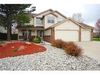 Charming two-story home featuring a well-manicured front yard with mature trees at 17722 E Ida Ave, Centennial, CO 80015