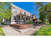 Charming multi-story home featuring a landscaped front yard and a classic brick facade with a welcoming covered porch at 2566 N Emerson St, Denver, CO 80205