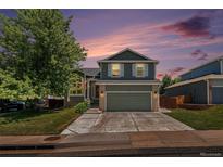 Charming two-story home with a well-manicured lawn, mature tree, and an inviting two-car garage at 5102 S Lisbon Way, Centennial, CO 80015