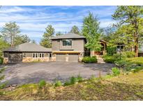 Stunning two-story home with an attached three-car garage and beautiful natural landscaping at 166 S Rainbow Trl, Evergreen, CO 80439