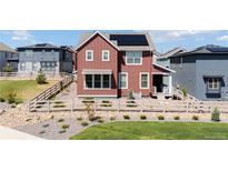 Attractive two-story home with solar panels, a fenced yard, and professional landscaping at 8372 Bijou Creek Ave, Littleton, CO 80125