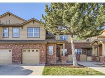 Charming two-story townhouse features brick accents, attached garage and a well-maintained lawn at 8915 Federal Blvd # 203, Denver, CO 80260