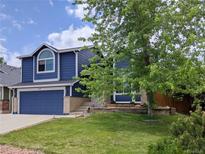 Charming two-story blue home with landscaped front yard and a blue two car garage door at 5695 W 109Th Cir, Westminster, CO 80020