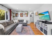 Bright living room featuring a comfortable gray sectional sofa and vibrant area rug at 5190 E Asbury Ave, Denver, CO 80222